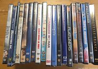 Front view of 19 sealed DVD spines showing titles and shrink-wrap
