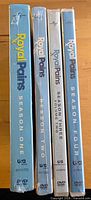 Four shrink-wrapped Royal Pains DVD season sets standing upright showing spines