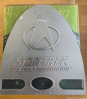 Front view of sealed Star Trek TNG complete series DVD box set showing Starfleet delta case and shrink wrap