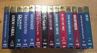 Front spines of 14 sealed James Bond MGM/UA VHS tapes lined side by side