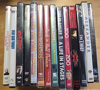 Spines of approximately 14 DVD cases, most visible in factory seal