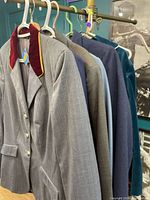 Row of seven blazers on rack