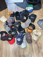 Group shot showing all 17 branded caps on floor