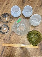 All seven glass pieces arranged on floor with ruler for scale