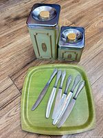 two metal canisters, tray, six knives