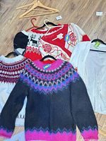 All six sweaters laid out on floor