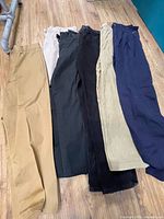 Six pairs pants laid out showing colors and fabric