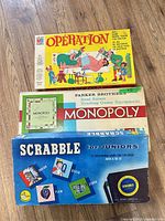 Stacked boxes: Operation, Monopoly, Scrabble Jr
