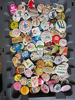 Tray containing over 100 assorted vintage pin-back buttons