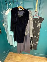 Five dresses hanging on door