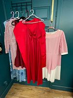 Six dresses hanging on door showing front views and colors