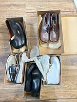 Overview of four boxes containing vintage children's shoes
