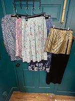 All garments hung on door showing variety of skirts and set
