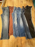 Six pairs of jeans laid side-by-side on floor