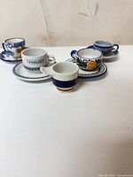 Group of assorted espresso cups and saucers visible