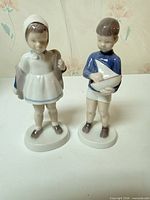 Both figurines standing side by side