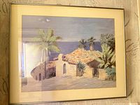 Full view of framed coastal print under glass with metal frame