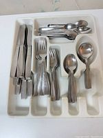 Tray containing assorted stainless steel knives, forks and spoons