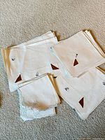 Stacked ivory placemats and napkins showing brown appliqué corners