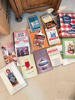 All 13 cookbooks and pamphlets arranged on carpet