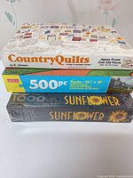 Stack of three puzzle boxes showing titles and piece counts