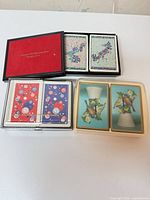 All items grouped: three plastic boxes of decks and black presentation case