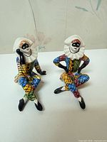 Both porcelain Harlequin figurines on tabletop