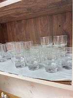 Group view of clear glass rocks tumblers on shelf