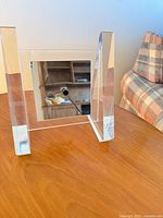 rear view of clear lucite frame holding mirrored clock face and movement stem