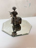 Full view of metal sculpture on mirrored base