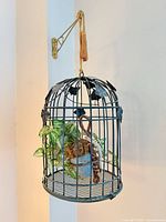 Full view of hanging birdcage planter on wall bracket