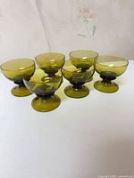 Six olive-amber footed sherbet glasses grouped together