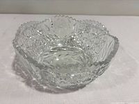 Top angled view of clear cut glass bowl showing pattern and scalloped rim