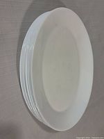 stack of eight white plates side view