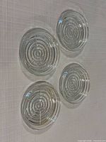 set of four clear glass coasters displayed on white surface