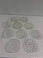 ten clear glass plates arranged on table displaying overall quantity and pattern
