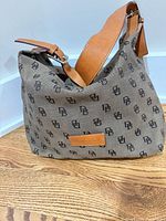 Front view of monogram canvas hobo bag showing leather strap and trim