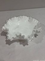 Top view of white milk glass bowl with clear ruffled rim