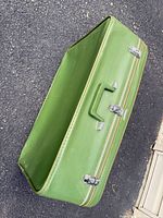 Open green vinyl suitcase showing interior and handle
