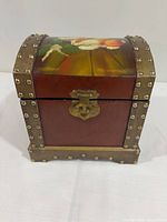 Front view of wood jewelry box showing floral lid painting, latch and stud trim