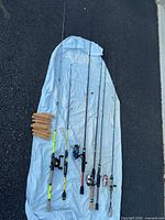 Group shot showing six rods with reels and loose cork handles laid on sheet