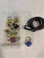 Assorted padlocks in tub, cable bike lock and combination lock overview