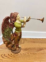 full view of multicolor resin angel figurine blowing trumpet