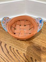 Top view showing woven terracotta basket form and painted handles