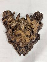 Front view of Green Man wall plaque showing carving details and candle holders