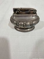 Front view of small silver-plated Ronson Crown table lighter showing overall design and tarnish