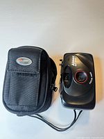 Front view of Aimex SP-800 camera beside Lowepro case