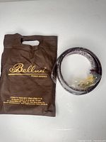 Belt coiled beside branded Belluni carry pouch