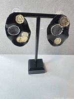 front view of both earrings on stand