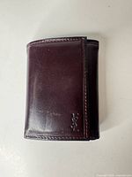 Front view of burgundy leather wallet closed showing YSL logo